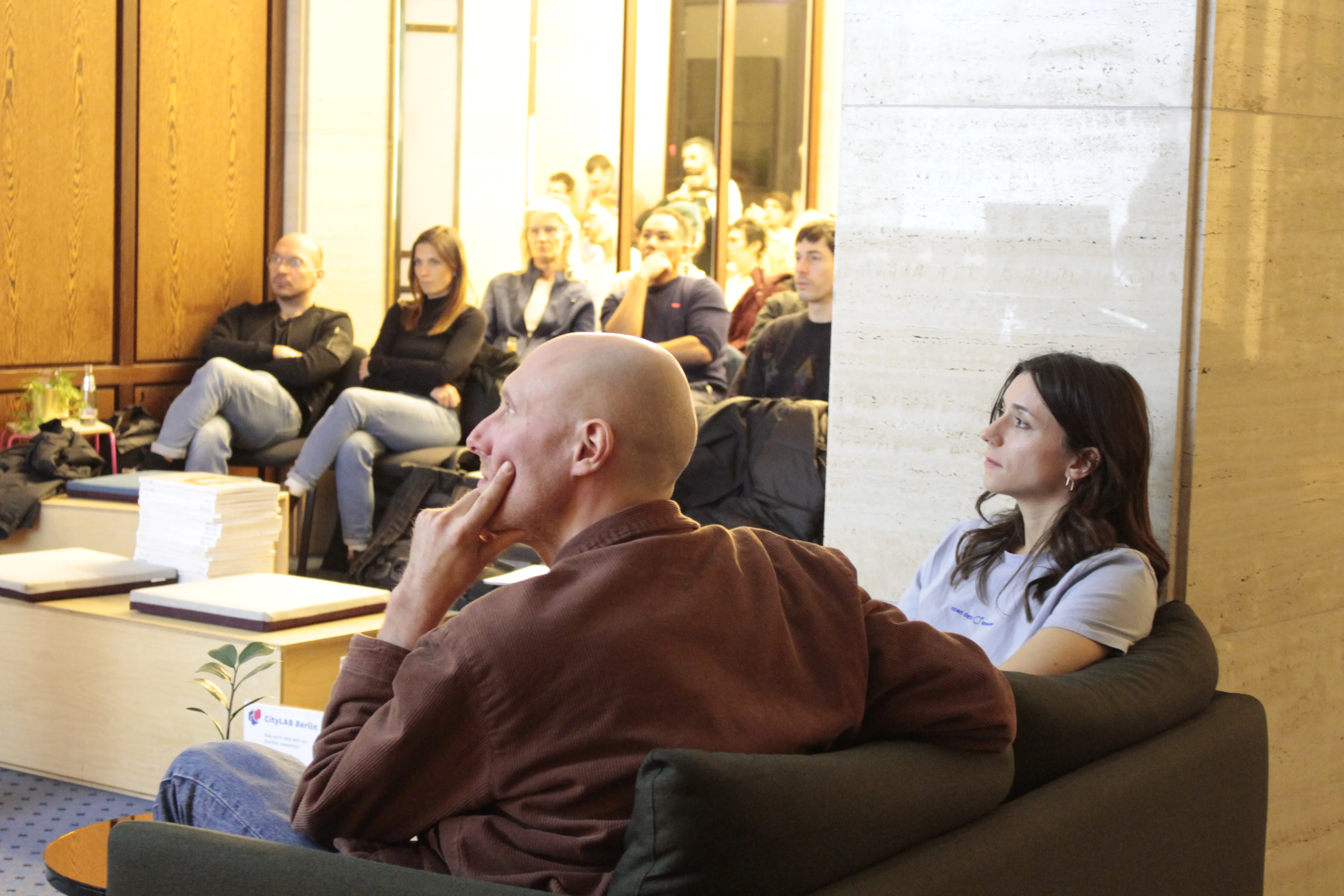 People sitting on a sofa looking at a presentation
